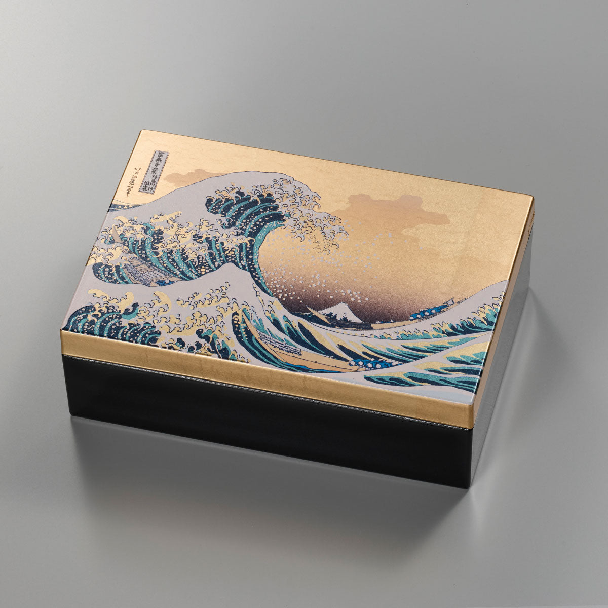 A decorative storage box with Japanese art-inspired design and foil accents. It is suitable for keeping small accessories, presenting gifts, or adding a compact Japanese craft item to gift and home interior displays.